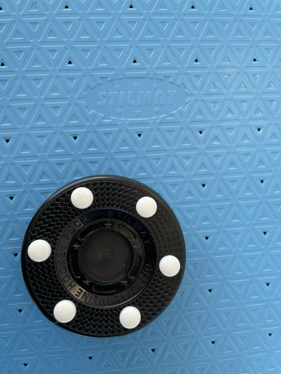 Official inline puck on the rink floor